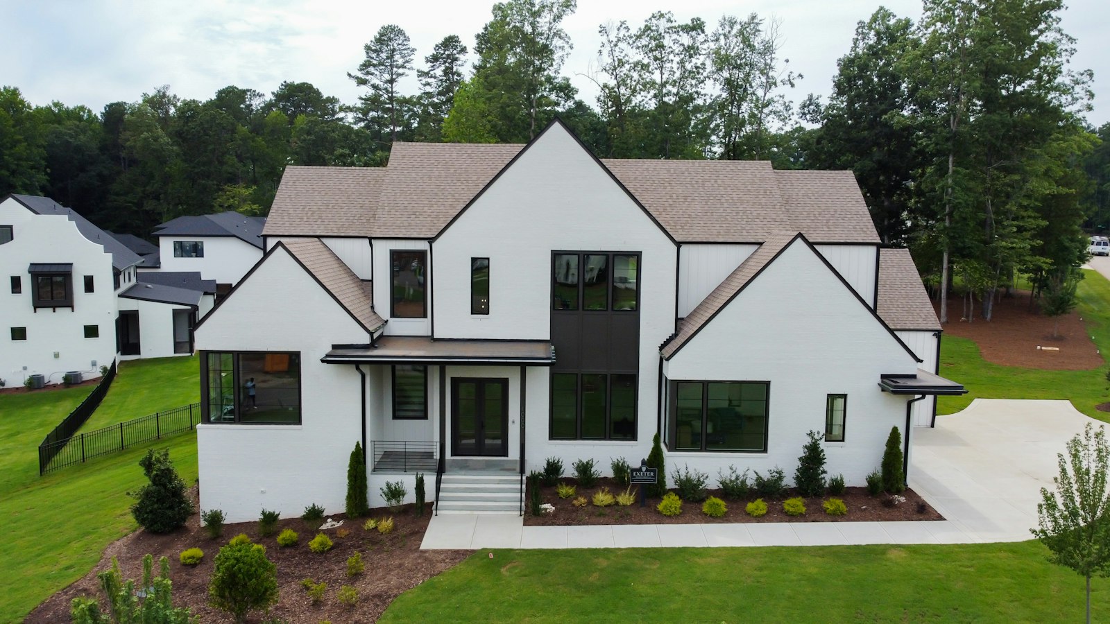 Modern white farmhouse with a shingle roof, illustrating wind and hail deductibles for Oklahoma homeowners